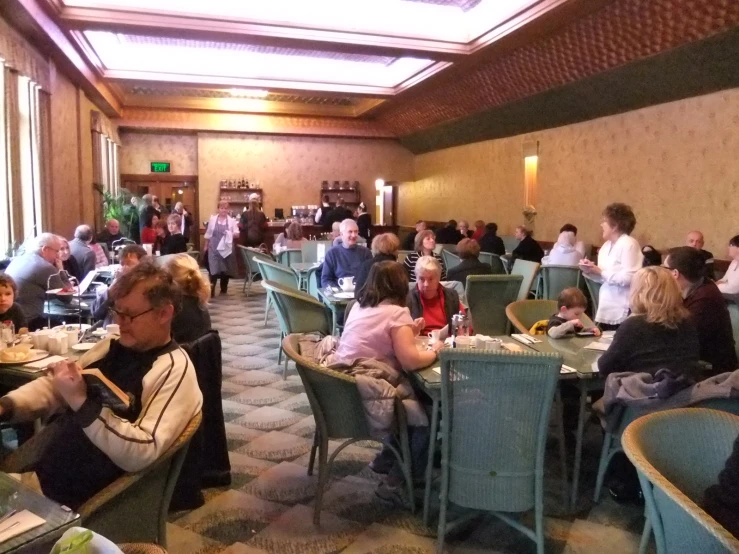 several people at tables eating at a restaurant