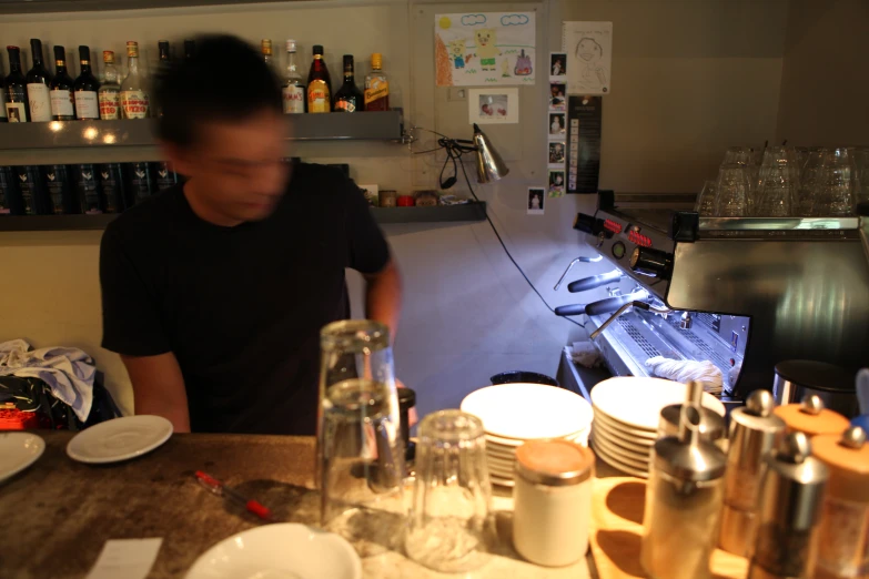 a bartender with lots of cups on the bar