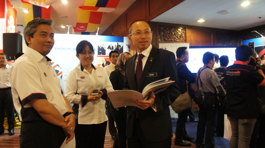 several people at an event, all wearing uniforms and holding a book