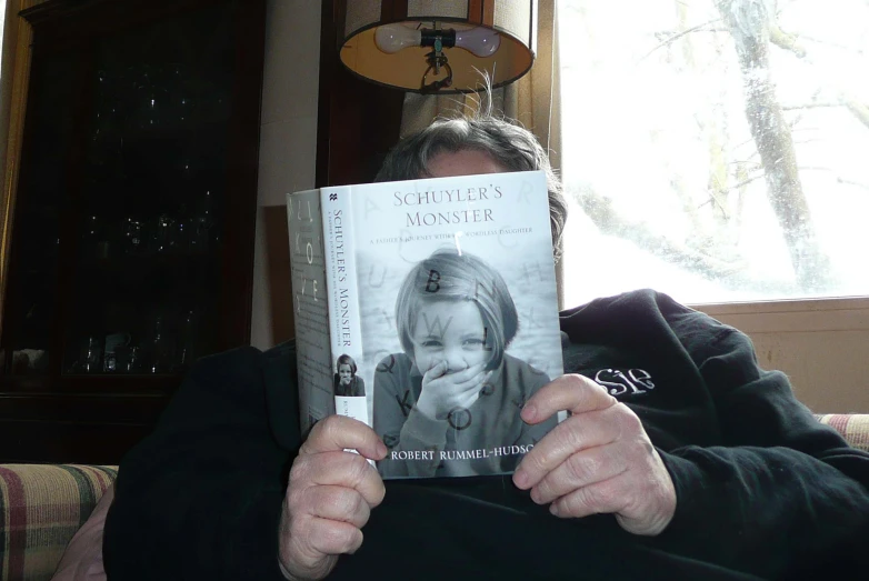 a man is sitting in a chair reading a book