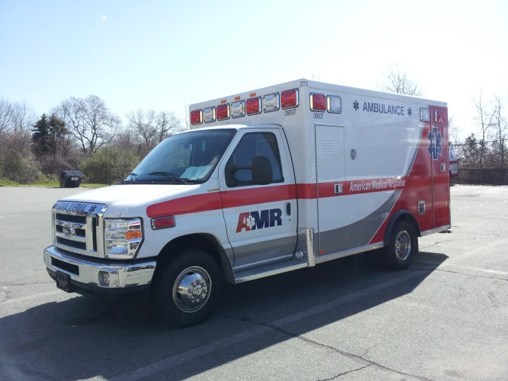 the ambulance is parked on the concrete in the parking lot