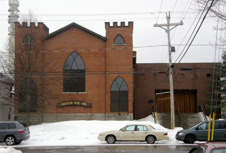 cars parked on a street corner and a church