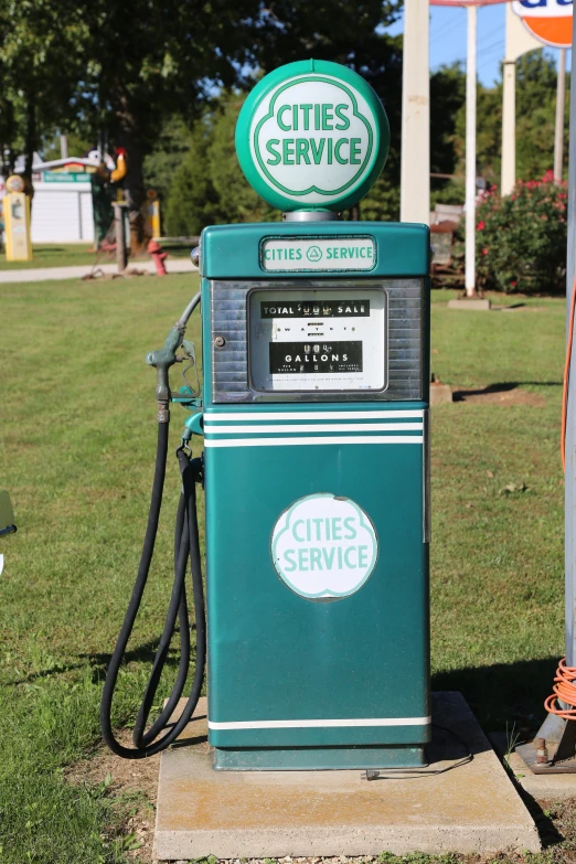 an old green gas pump sitting on top of a field