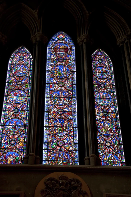 two stain glass windows are visible behind a wall