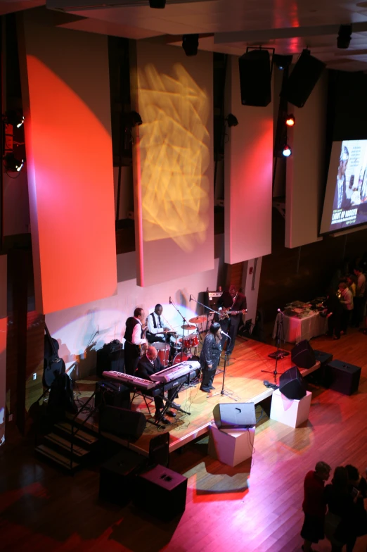 a group of people playing on the stage in a big room