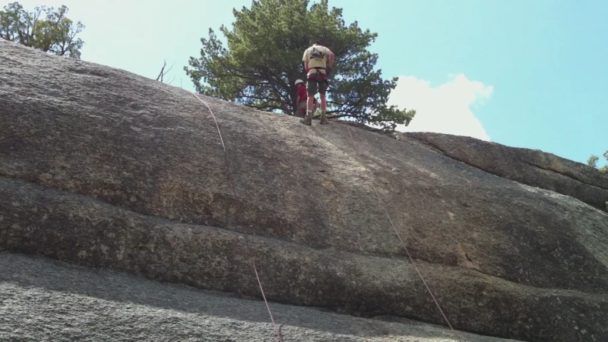 a man standing on the top of a mountain with a parachute