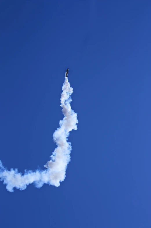 a person standing on the top of an airplane in the sky