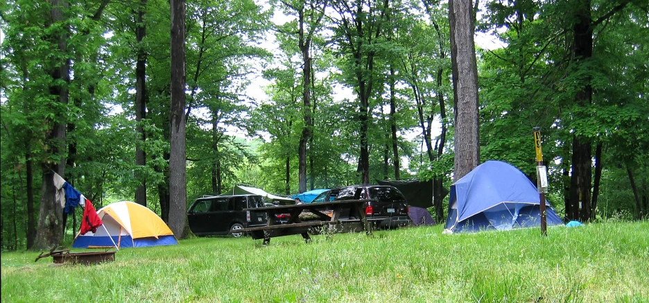 a tent and several tents set up in the woods