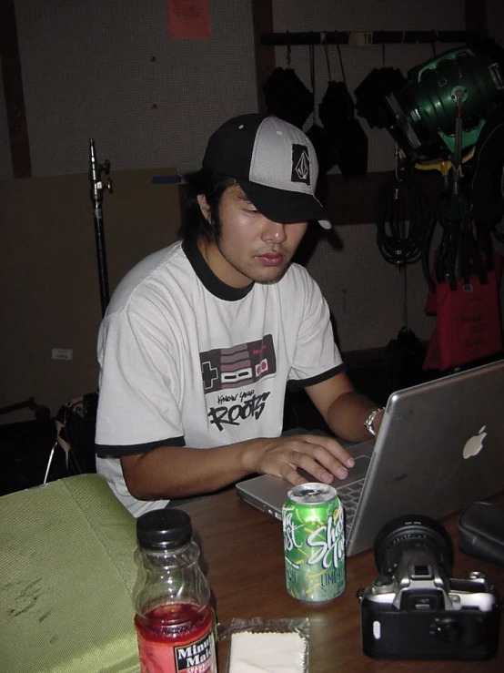 a man sitting at a table using a laptop computer