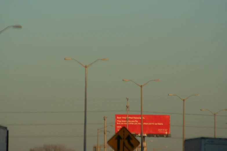 some street lights and a sign are in the sky