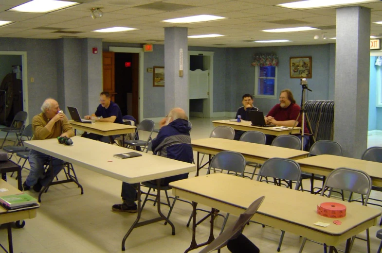 a class room with desks and laptop computers