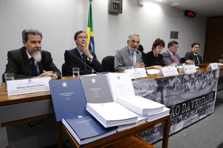 a group of people sitting at a table in front of two men