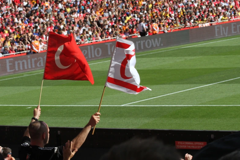 two flags in the air with people watching