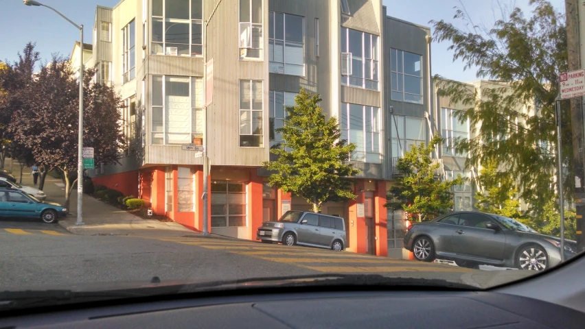 a building with cars parked along the street on either side