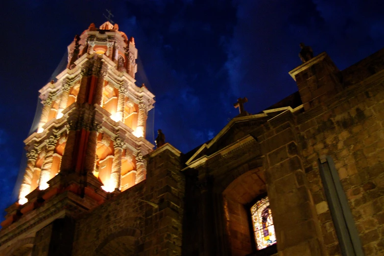 a tall clock tower with windows and lights lit up at night