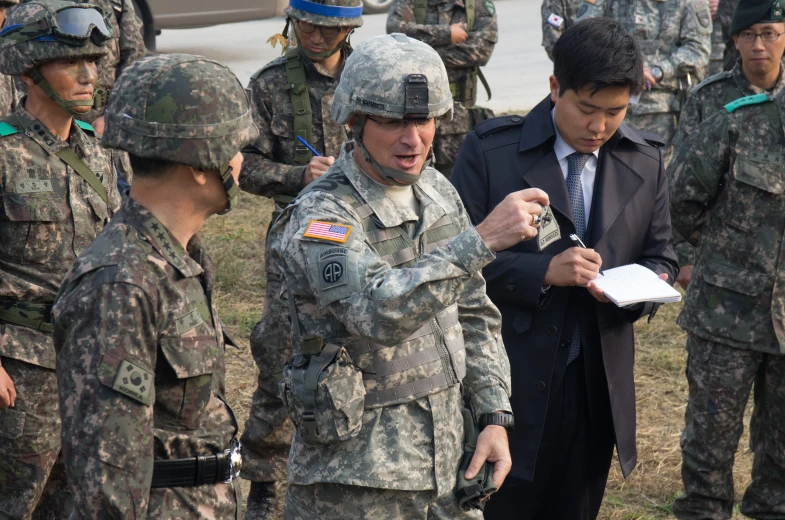 two men in military fatigues are reading soing