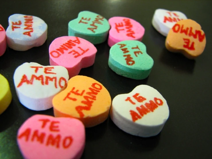 some candy hearts with different colors and writing on them