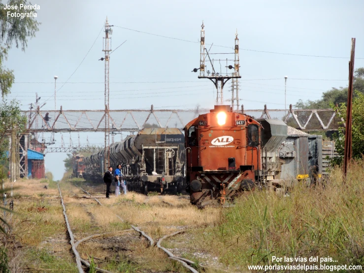 an old train with people looking on next to it