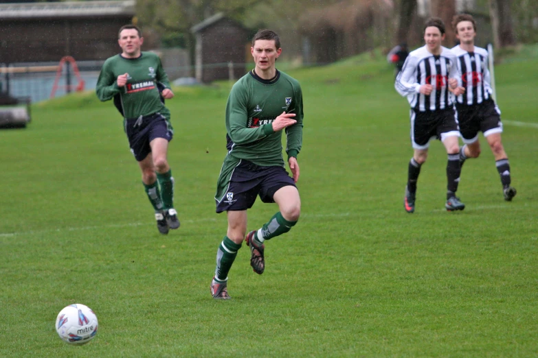 there are three men that are playing soccer