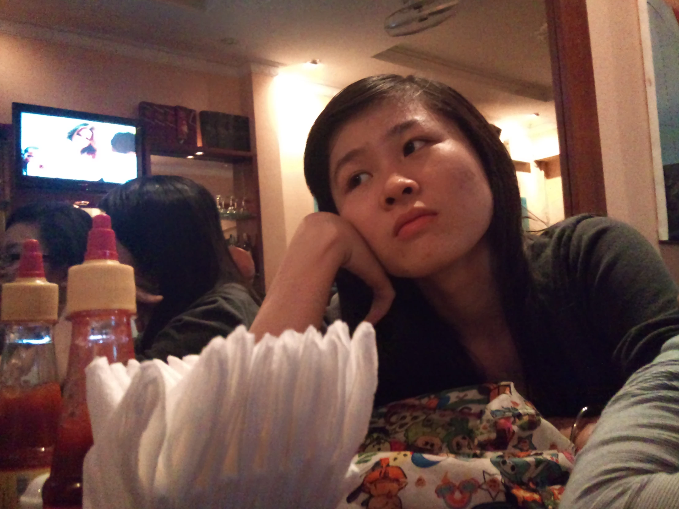 a woman sitting at a table with a cup and saucer in front of her