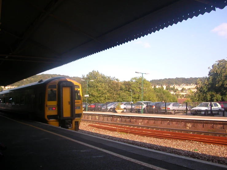 there is a yellow train parked at the platform