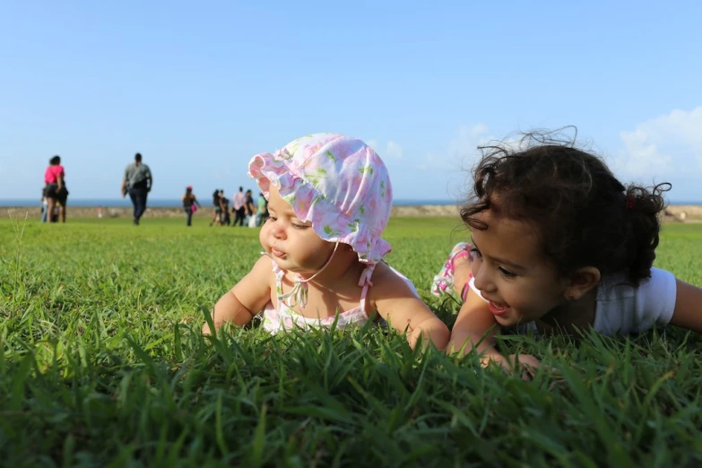 two s laying on the ground in grass