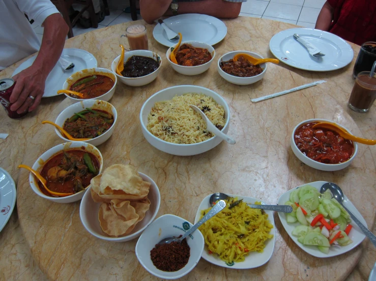 a circular wooden table with bowls of food on it