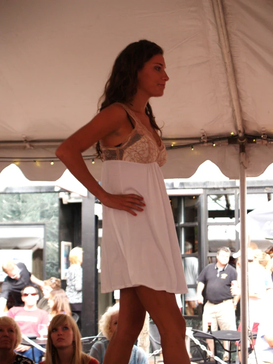 a young woman modeling a white dress on the catwalk