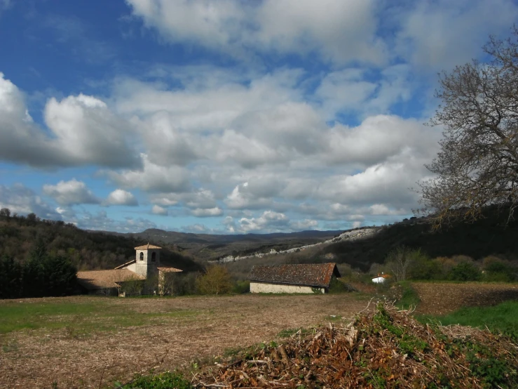 a landscape view shows a rural house in the background and trees on either side