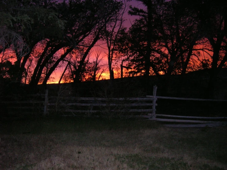 a sunset s looking out over a fence