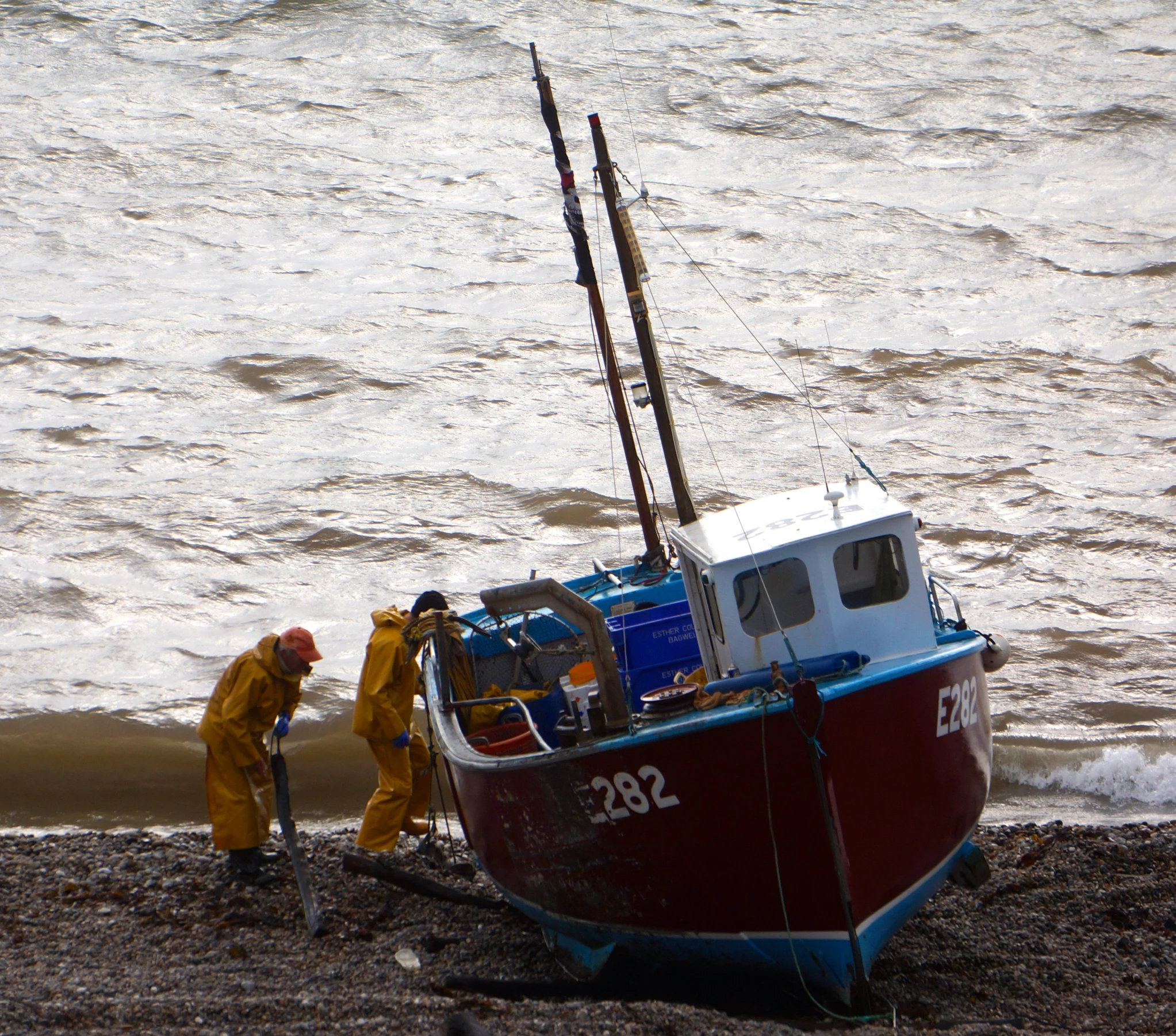 a man in yellow clothing working on a boat