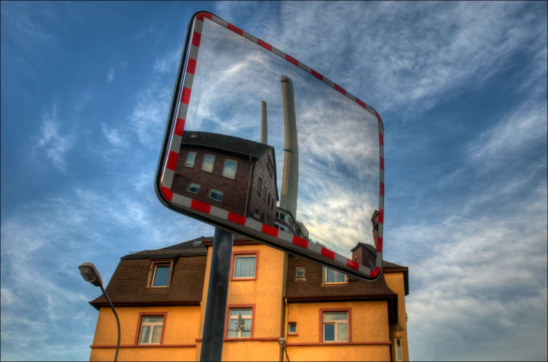 a street sign that is upside down next to a building