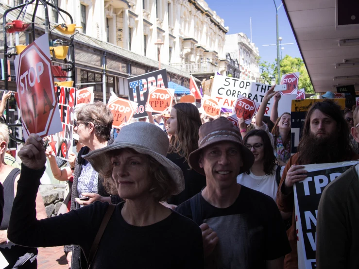 a group of people holding signs standing in front of a building