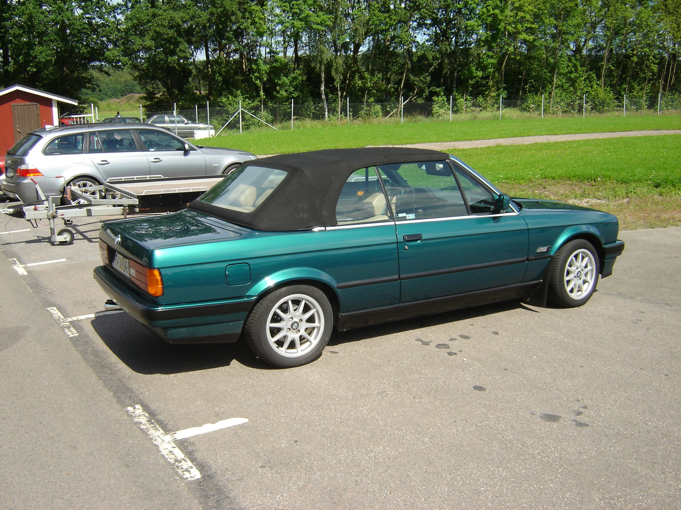 a green car is parked in a parking lot