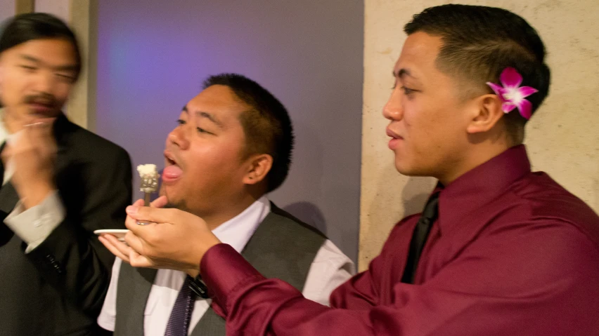 three men laugh and eat cake with candy