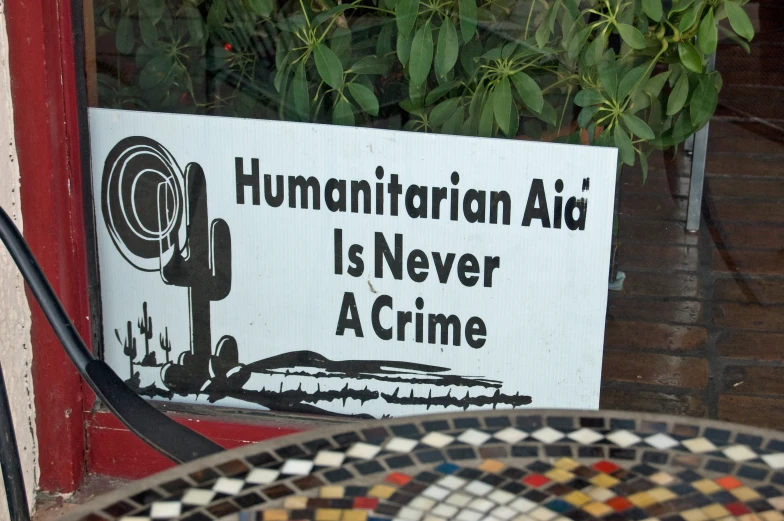 the sign in the window tells that human rights are never a crime
