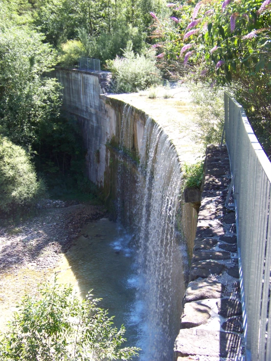 a water fall sitting next to a wooden fence