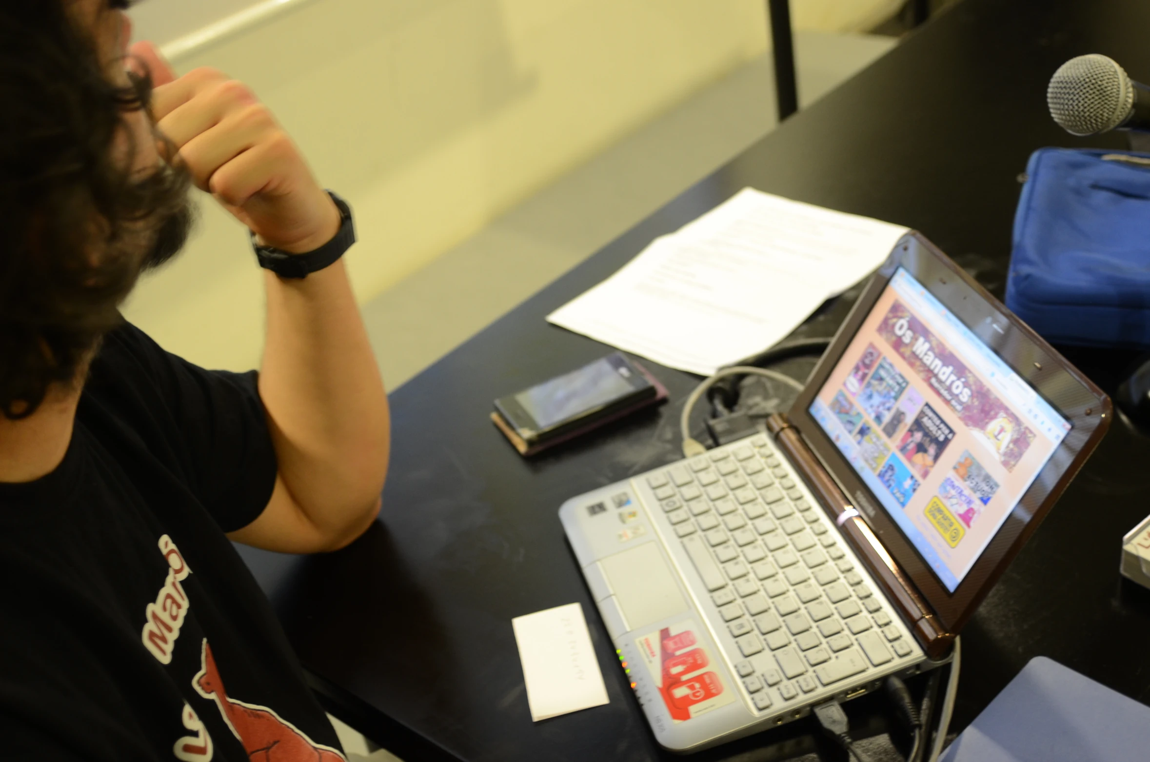 there is a man sitting at a desk in front of a laptop