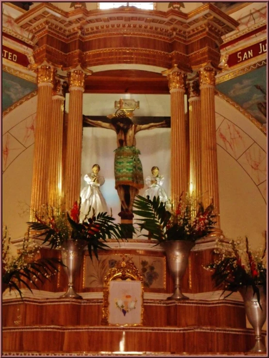 a statue in the front of a church with an image on the cross behind it