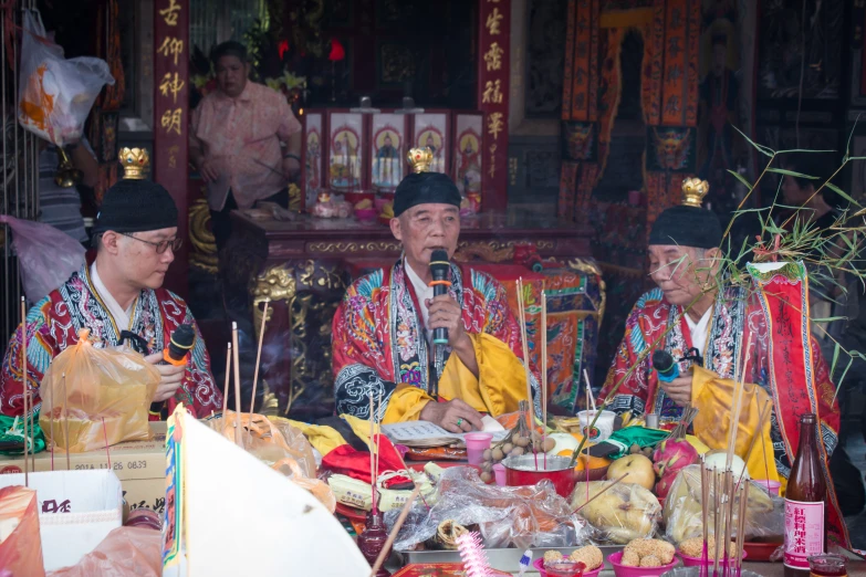 a group of men sitting down with food and drink