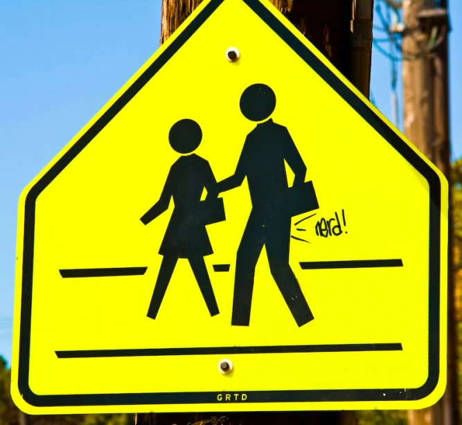 this is a yellow crossing sign with a child walking on it