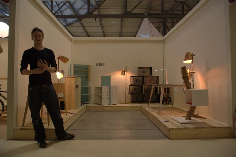 man standing in an open room with multiple sculptures in the foreground