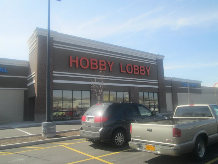 a large hobby shop with cars parked outside