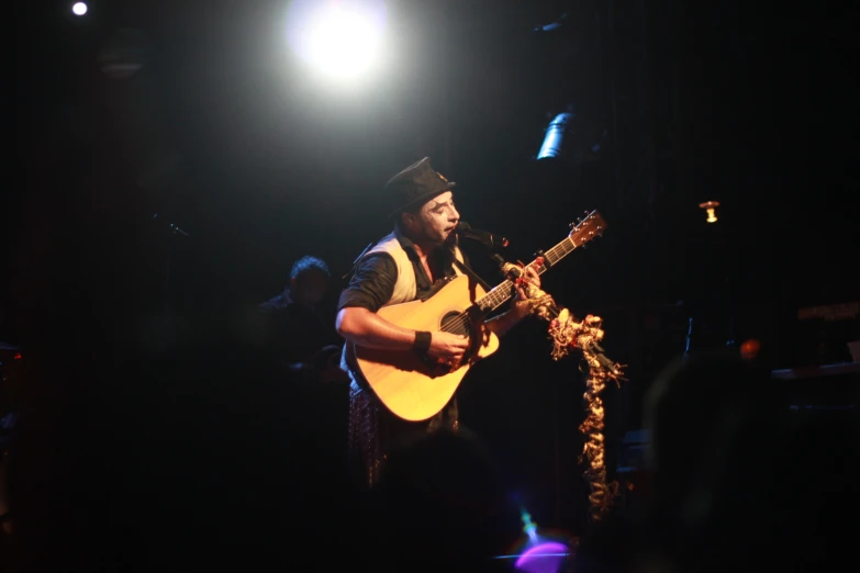 a man on stage playing a guitar at a concert