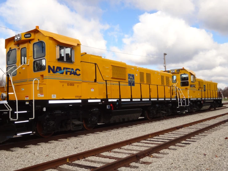 a yellow train with words nfsc sits on a track