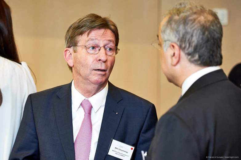 a man in a suit speaking to three others