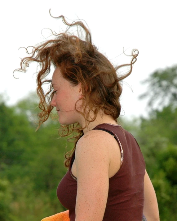 a woman standing outside with long hair in the wind