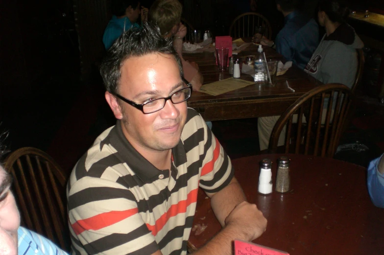 a man sitting at a table with a beer