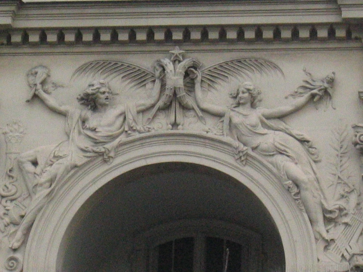 a door is decorated with carved statues on it