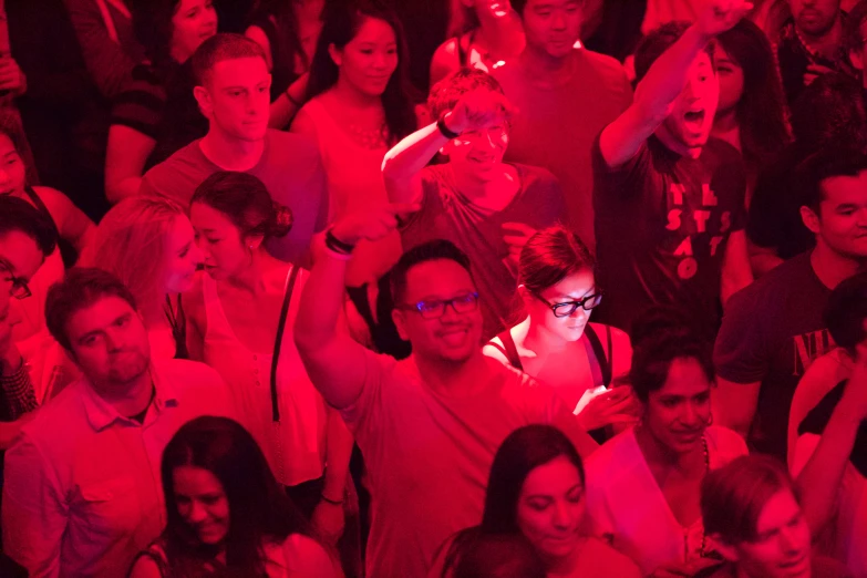 a group of people with their arms in the air and a lady showing them phone